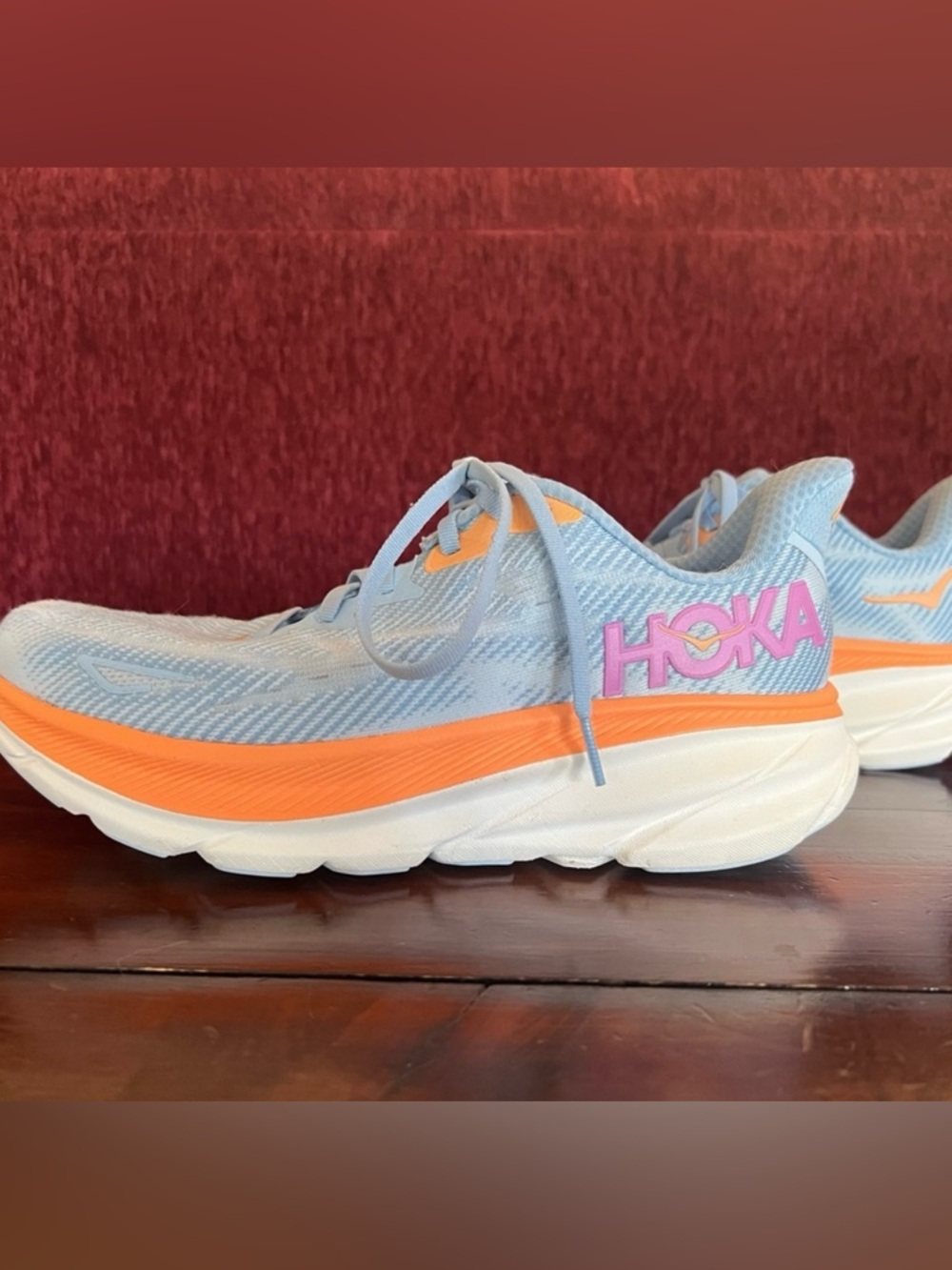 Hoka Women's Light Blue Running Shoe with Orange Midsole and Pink Logo